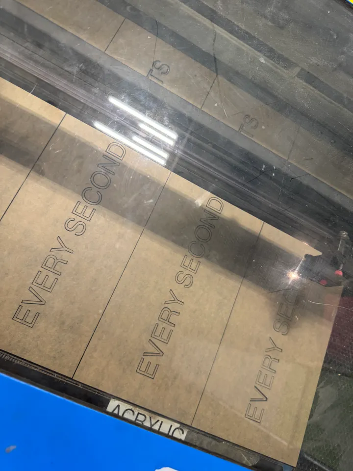Three “Every Second Counts” panels cut side by side in acrylic inside the laser cutter