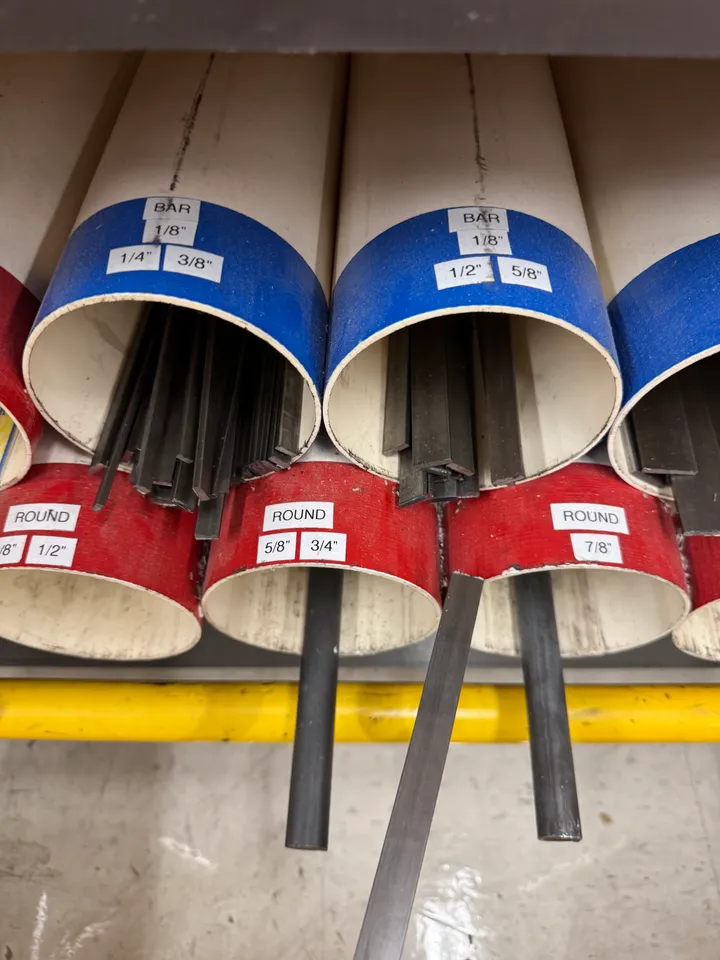 Bins of steel bar stock in a store rack, sorted by shape and size