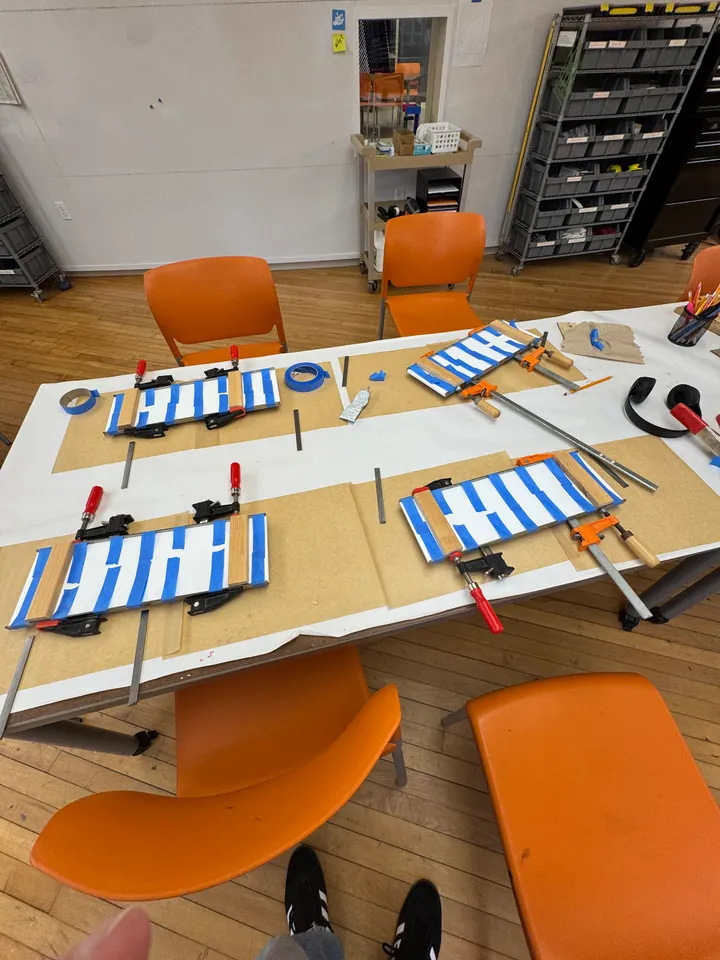 Three sign frames glued and clamped on a table in the makerspace