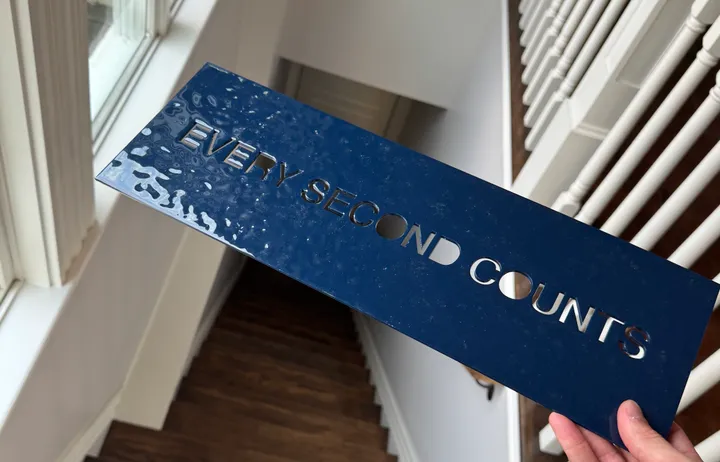 Holding a navy panel over the stairs, its epoxy surface rippled and shiny