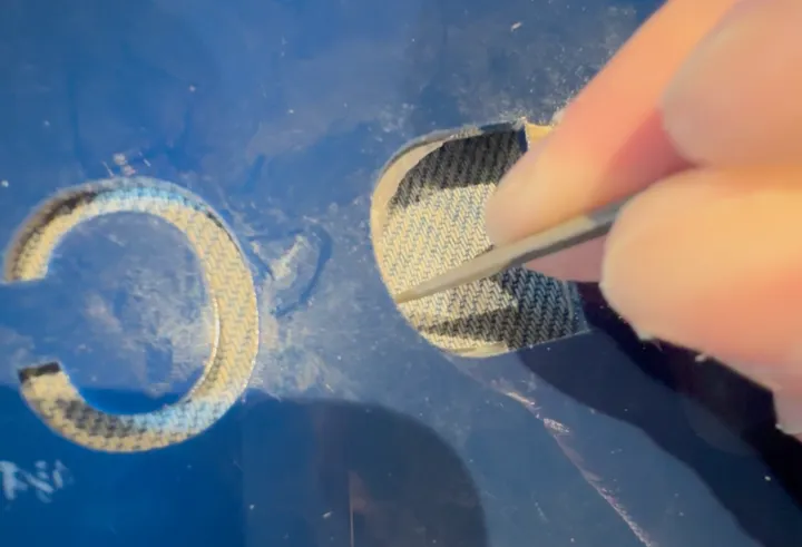 Picking cured epoxy out of a letter hole with a needle tool