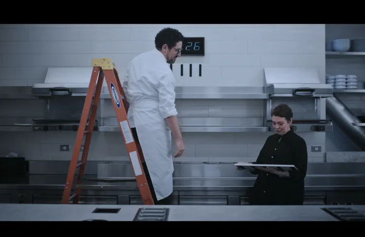 Season 3 still: Chef Terry holds the sign flat while a chef stands by the ladder